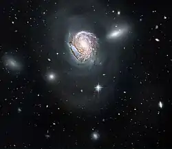 A face-on view of a spiral galaxy (NGC 4911) located deep within the Coma Cluster