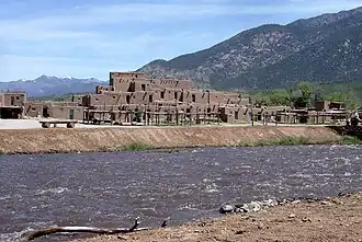 Taos Pueblo, a World Heritage Site, belonging to a Native American tribe of Pueblo people, marking cultural development during the Pre-Columbian era