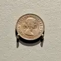 One shilling coin stamped "DUD".