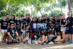 A gathering of Filipinos holding a sign that identifies them as "Pinoy"
