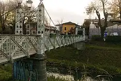 Simple iron pedestrian bridge crossing a river.