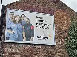 Ghost sign for Solo-branded margarine covered by a modern billboard, in Binche, Belgium.