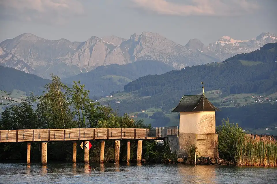 The wooden bridge and the bridge chapel as seen from the nearby Seedamm, Wägital in the background