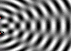 Wave interference in water due to two sources marked as red points on the left