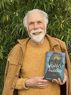Robert Kehlmann poses with his book, The Rabbi's Suitcase.