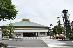 Street view showing the entrance of the arena, the Kokugikan is seen afar, a tower guards the entrance