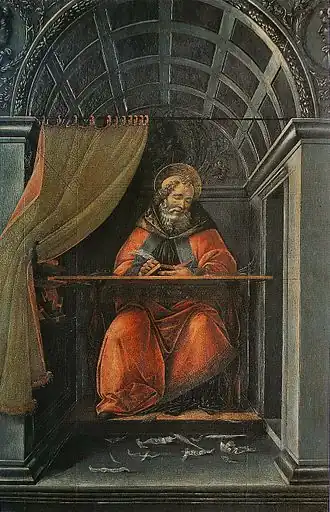 bearded man in red clothing writes at a desk in a room with an arched ceiling