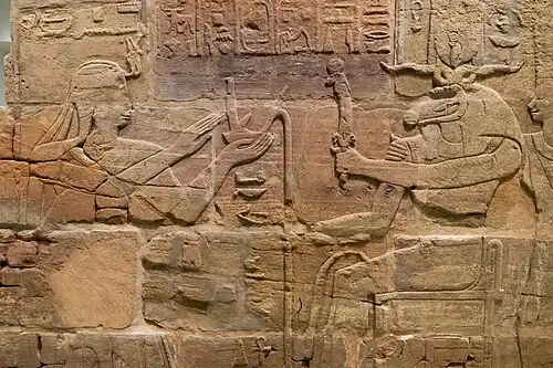 Sandstone wall of King Aspelta offering Ma'at (Truth) to ram-headed god Amun-Re accompanied by Anukis, Temple T at Kawa Ashmolean Museum I9J2.I295.[8]
