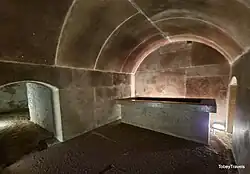 Photograph of a vaulted red granite chamber and sarchophagus