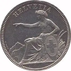 Helvetia seated, holding shield bearing the Swiss Cross, pointing left. Legend above.