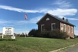 One-room schoolhouse, built 1858, by entrance to cemetery