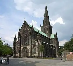 black weathered stone cathedral showing west front stained glass window