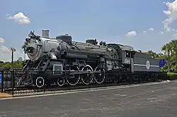An old steam locomotive on static display with faded paint