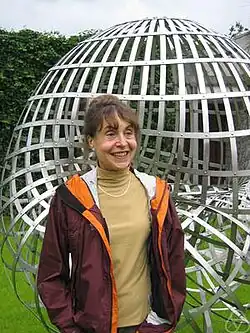 The mathematician Stephanie Alexander stands in front of a steel plate sculpture of the Boy Surface.