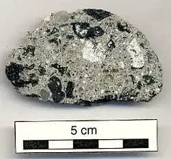 A 5cm wide suevite(with white black and grey spots) from the impact crater at Lahojsk, Belarus