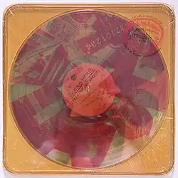 A yellow plastic case with clear vinyl albums inside that have red and blue photographs stamped onto them