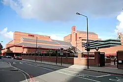 A photograph of the British Library showing a blue sky and red bricks.