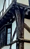 image of the corner timbers of the House That Moved, with three distinct timbers splaying out and supporting the dragon beam, which is a diagonal horizontal beam, with an overhang on two sides