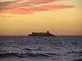 The Spirit of Tasmania sailing through Port Phillip in dusk seen from Elwood Beach
