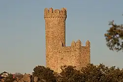 Small stone watchtower on a hill, with a clear blue sky on the background