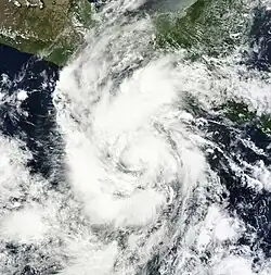 Satellite image of Carlotta developed a ragged central dense overcast, with a large area of thunderstorms and clouds.
