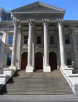 A close-up of the front steps and entrance portico of the Tweed Courthouse