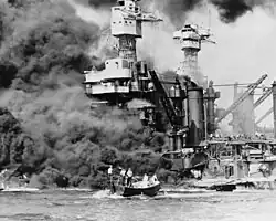 Hyperboloid mast towers were on the USS West Virginia aflame at Pearl Harbor on December 7, 1941, and a small boat rescues a seaman.