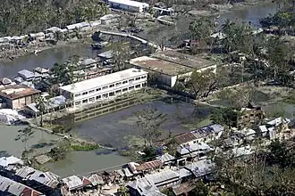 large areas of still water behind riverside buildings