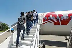 Venezuelan men boarding an aircraft