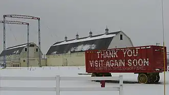 Two white wooden barns and a red wooden rail car