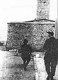 Polish resistance fighters from the "Giewont" company of the "Zośka" battalion secure Gęsiówka after the liberation. The crematorium building is visible in the background