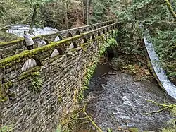 The 1939–40 WPA stone bridge across the creek, with main falls above it