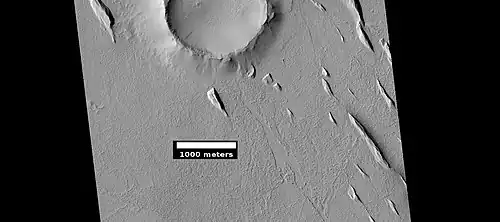 Yardangs near a crater, as seen by HiRISE under HiWish program. Location is in the Amazonis quadrangle.