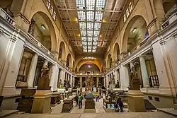 Interior view of the museum's main hall showing large stone artifacts and statues under modern lighting