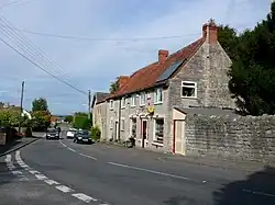 Stone shop building with cars parked outside