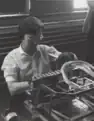 Inserting plug and bridge wire into electric blasting caps, 1955